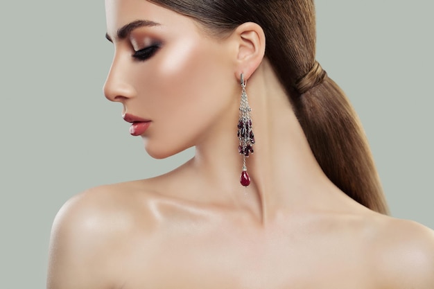 Beautiful woman portrait profile Female model with makeup and fashion jewelry earring