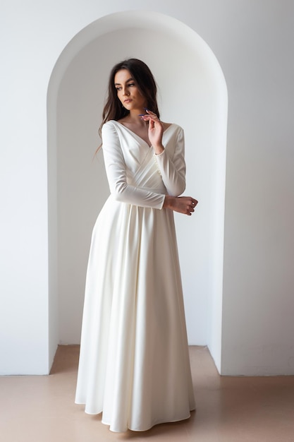 The beautiful woman posing in a wedding dress