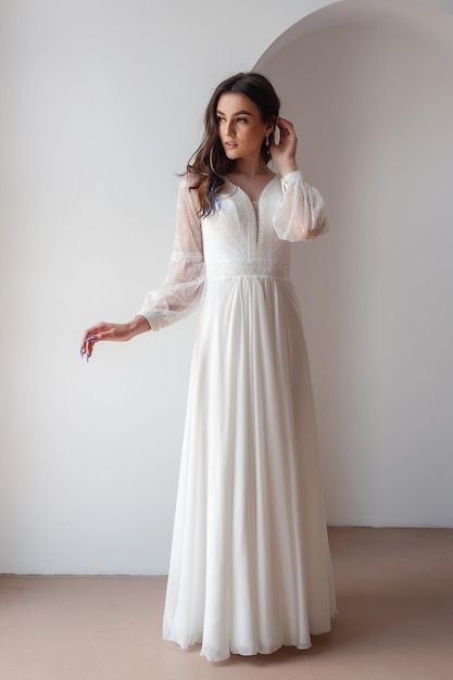 The beautiful woman posing in a wedding dress