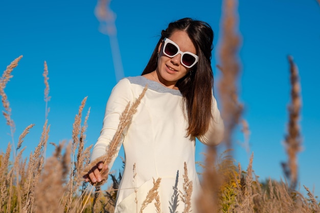 Beautiful woman posing in wheat field blue sky