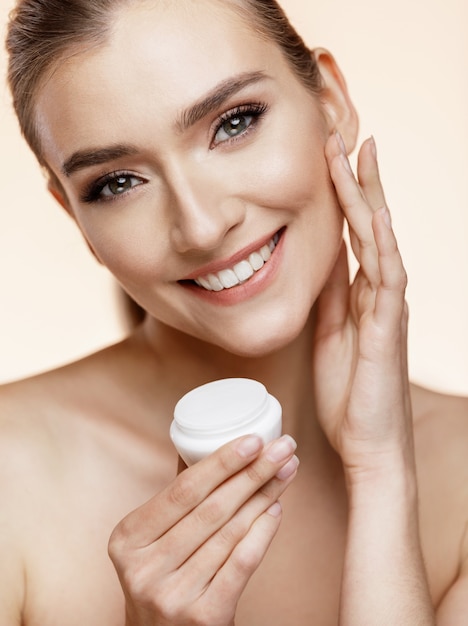 Beautiful Woman posing while holding a cream