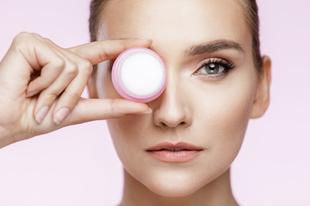 Beautiful Woman posing while holding a cream