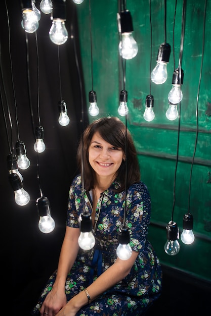 Beautiful woman posing with hanging light bulbs