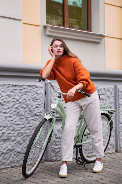 写真 通りで自転車でポーズをとって美しい女性