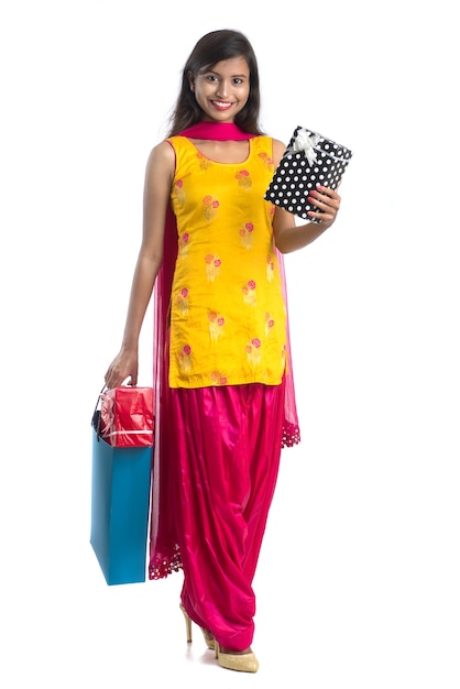 A beautiful woman posing with a shopping bag and gift Boxes on a white.