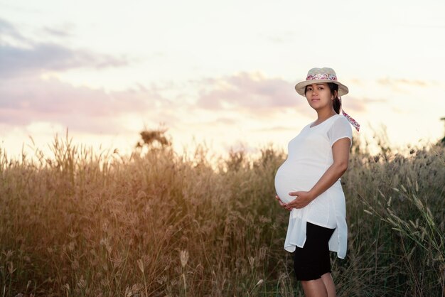 Красивая женщина, беременная женщина с фоном заката