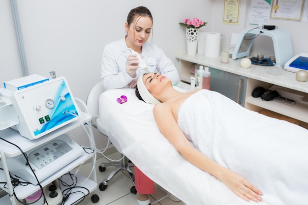 Bella donna nel salone di bellezza professionale durante la procedura di ringiovanimento giovane donna in una bellezza s