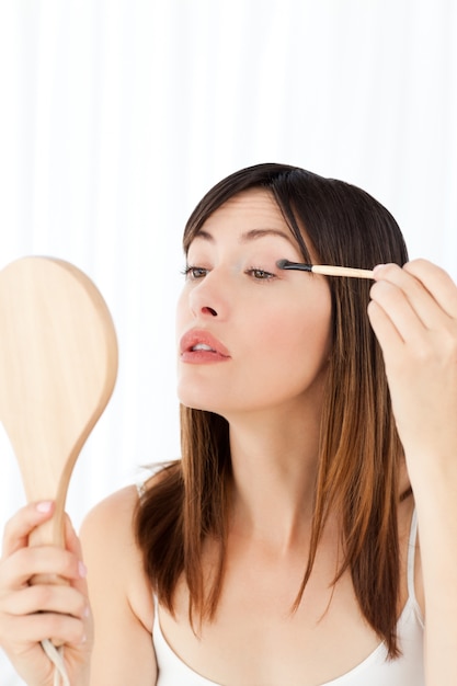 Beautiful woman putting on Make up