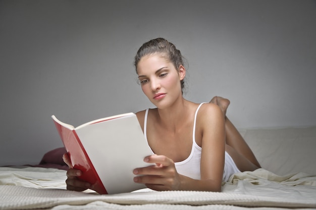 Beautiful woman reading in bed