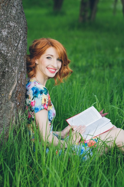 Beautiful woman reading a book in the spring garden