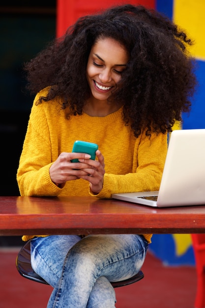 Beautiful woman reading text message on cellphone at cafe