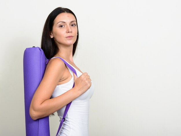  beautiful woman ready for gym against white wall