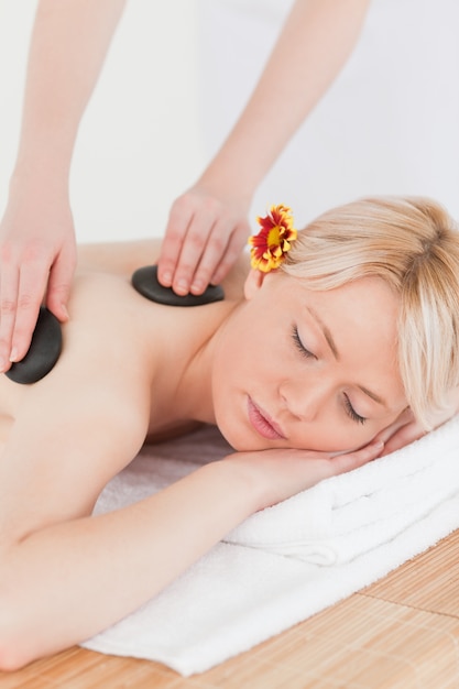 Beautiful woman receiving a massage with hot stones