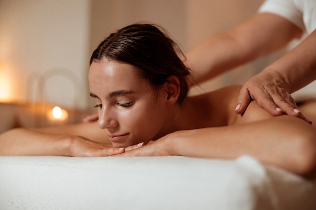 Beautiful woman receiving professional massage at wellness center