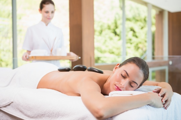 Beautiful woman receiving stone massage at health farm