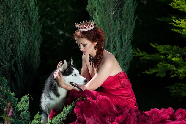 Beautiful woman in red dress with husky dog