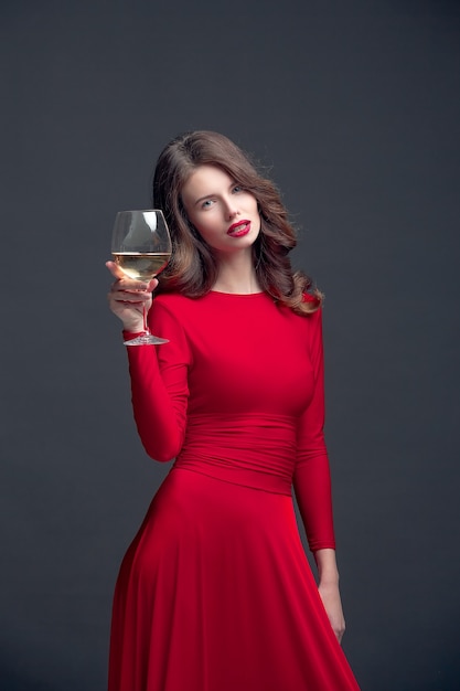 와인 글라스와 빨간 드레스에서 아름 다운 여자