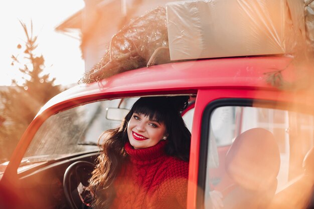 赤いヴィンテージ車で美しい女性