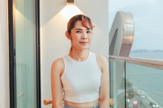 Beautiful woman relax on hotel terrace with ocean view in summer