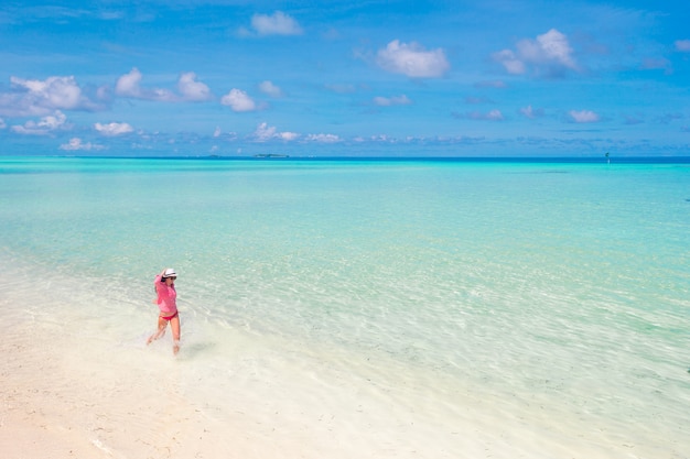 Foto bella donna che si distende alla spiaggia tropicale di sabbia bianca