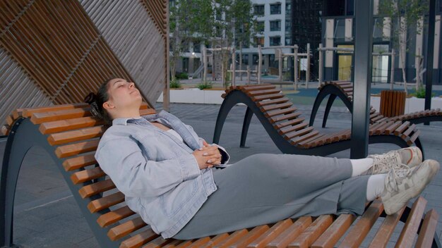 A beautiful woman resting on the street media after a hard days work rest on a bench in a quiet