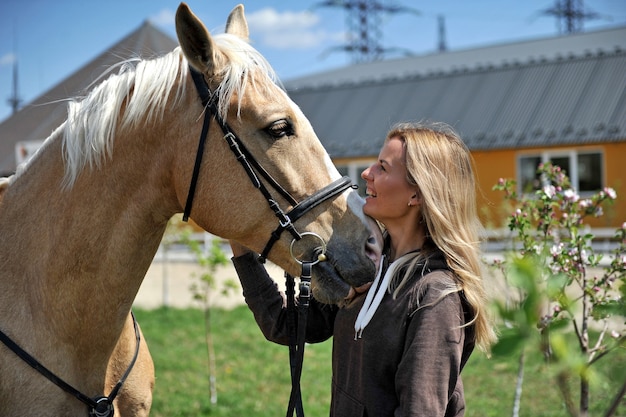 Beautiful woman rider jockey having fun with her favorite horse. Tenderness, love and animals concept.