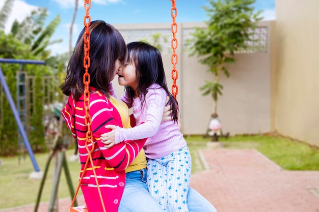 Beautiful woman rubbing her nose with her child