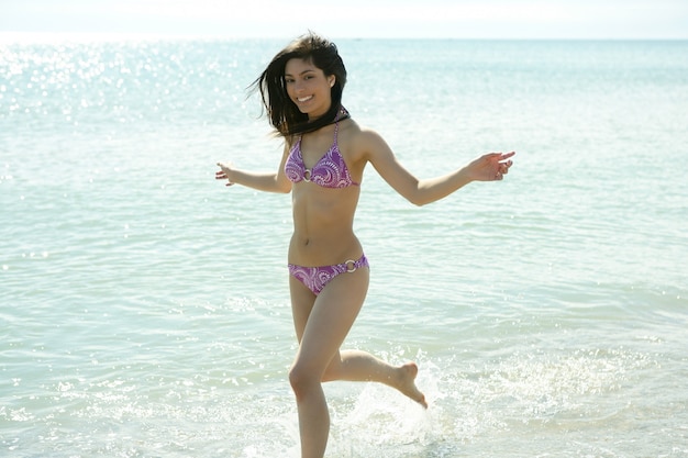 Beautiful woman running in bikini on the beach