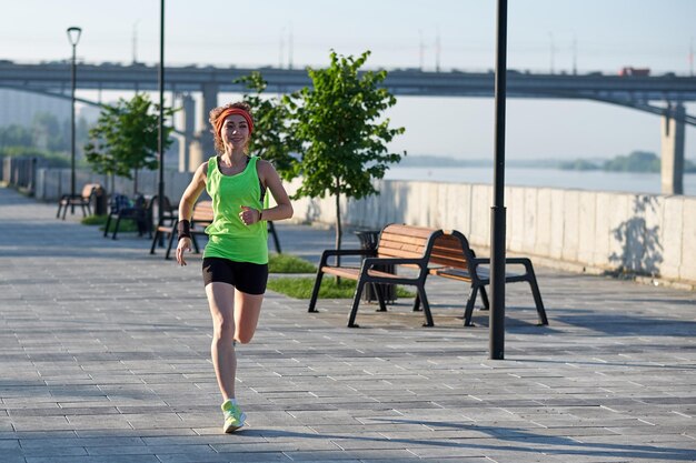 Beautiful woman running over bridge during sunset