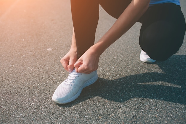 Photo beautiful woman running during sunset. young fitness model near seaside. dressed in sportswear. cords sneakers