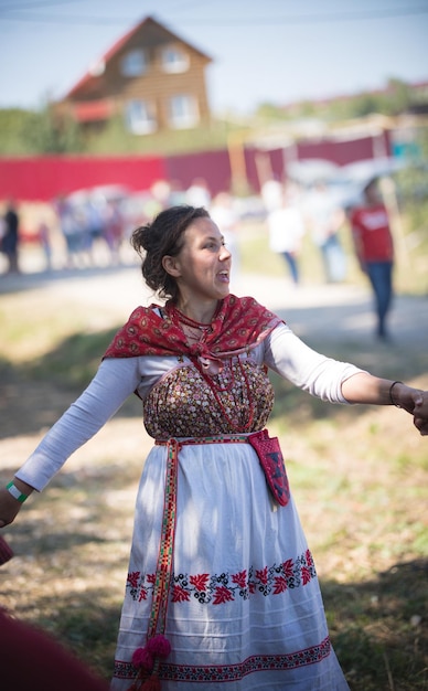 Beautiful woman in russian national costume dances and sings