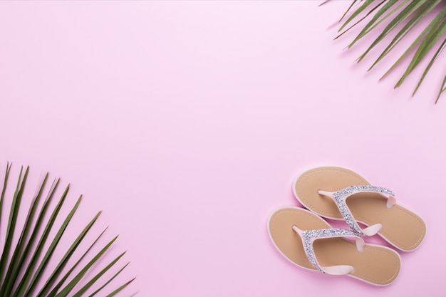 Beautiful woman's beach flip-flops on the light pastel pink background. beach summer concept and holiday concept, top view