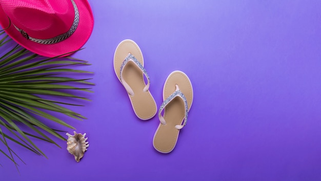 Beautiful woman's beach flip-flops on the violet or purple background. beach summer concept and holiday concept, top view