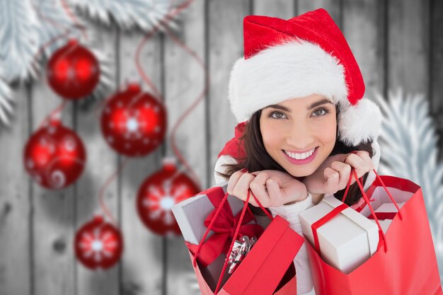 Beautiful woman in santa hat holding bags with gifts