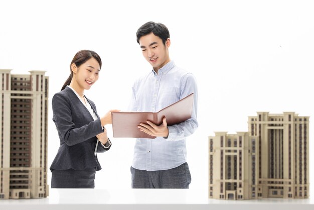 Beautiful woman selling residential property with her customers