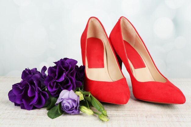 Beautiful woman shoes with flowers on bright background