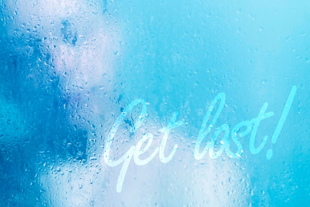 Beautiful woman in the shower behind glass with drops and inscription get lost