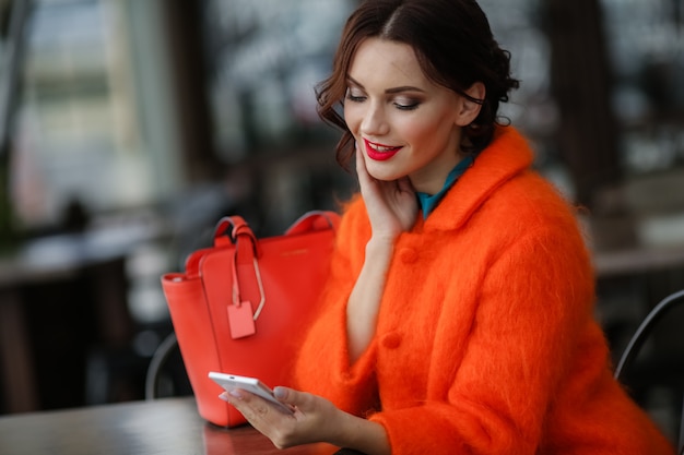 Photo beautiful woman sits at a table in a street cafe