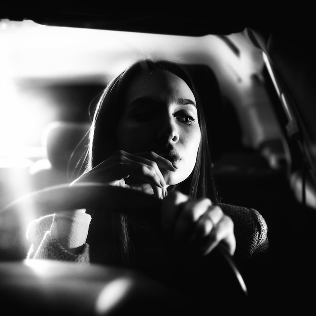 夜に車に座っている美しい女性