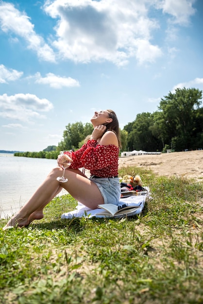 Beautiful woman sitting near the lake summer day