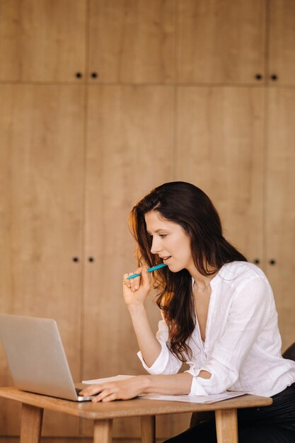 Beautiful woman sitting in the office working on a laptop