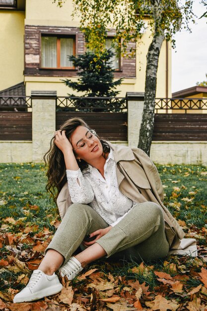 Foto bella donna seduta nel parco autunno natura stile di vita ritratto di una bella modella femminile