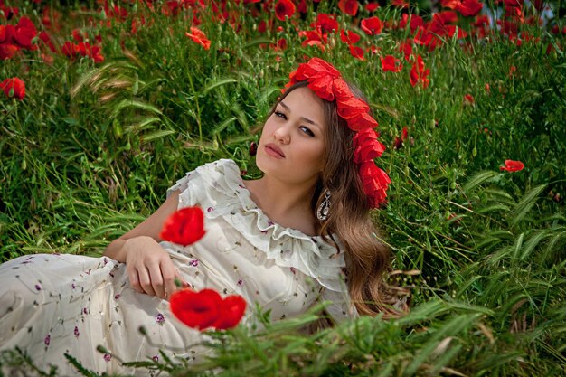 Beautiful woman sitting in the poppy flower