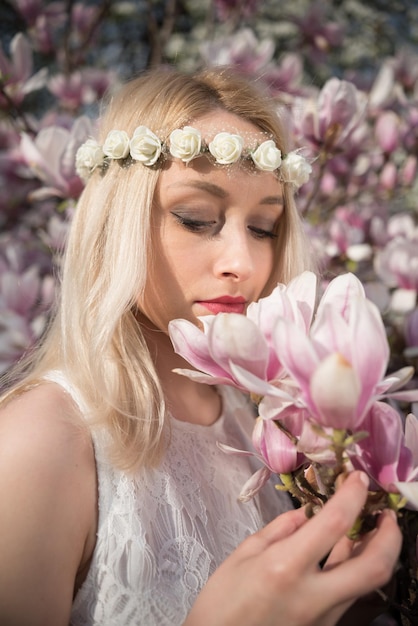 写真 美しい女性が花の香りを嗅いでいます