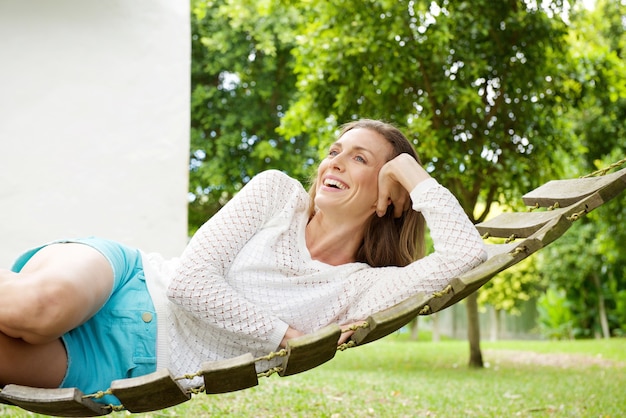 Beautiful woman smiling on hammock outdoors