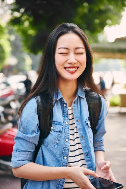 美しい女性が屋外に立って笑顔を浮かべている
