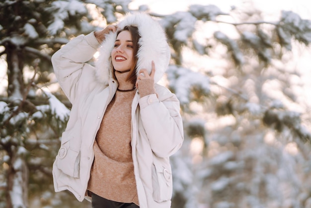 Bella donna in un parco innevato giovane donna che cammina in una soleggiata giornata invernale