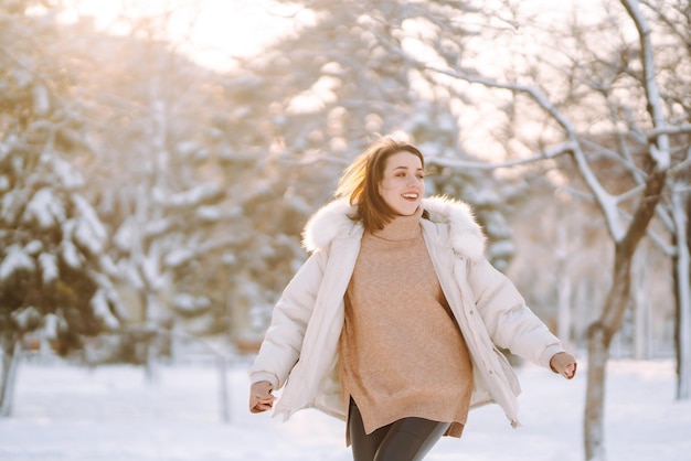 雪に覆われた公園の美しい女性晴れた冬の日に歩く若い女性