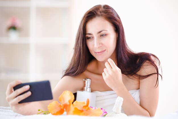 Beautiful woman spa holding smartphone