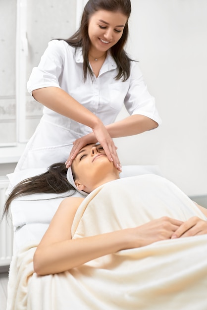 beautiful woman in spa salon getting face treatment